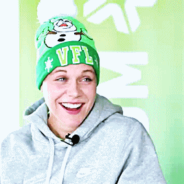 a woman wearing a green beanie that says vfl