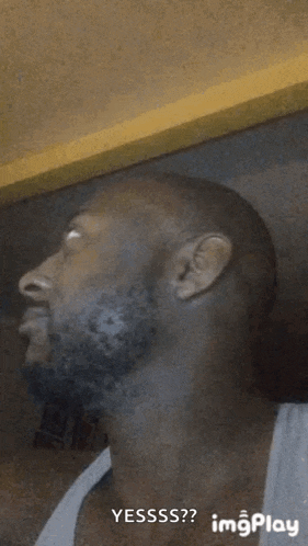 a man with a beard is making a funny face and looking at the camera .