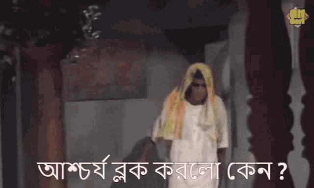 a man with a yellow scarf around his head is standing in front of a sign that says ' shree ' on it