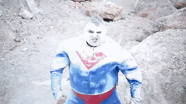 a man in a superman costume is standing in a field
