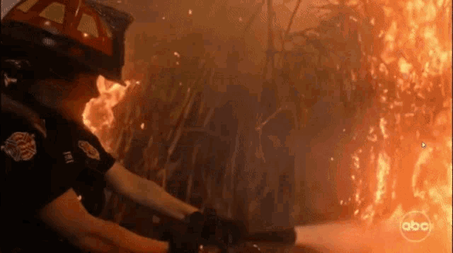 a fireman is spraying water on a fire with abc written on the bottom