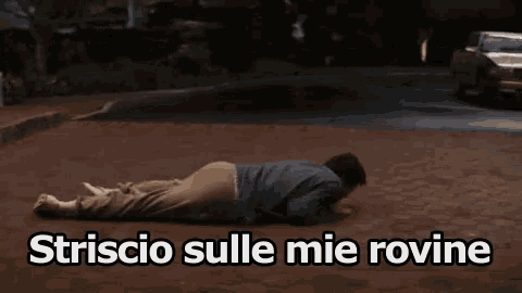 a man is laying on the ground with the words striscio sulle mie rovine written above him