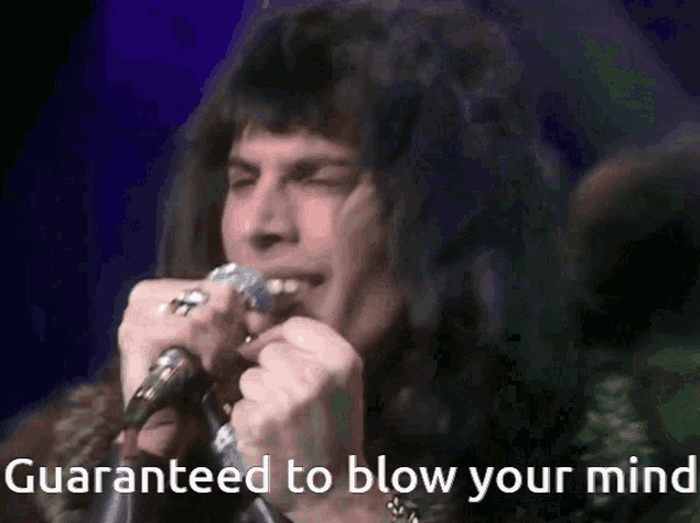 a man singing into a microphone with the words " guaranteed to blow your mind " next to him