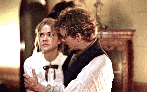 a man and a woman are standing next to each other in a room .