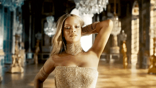 a woman in a gold dress stands in a room