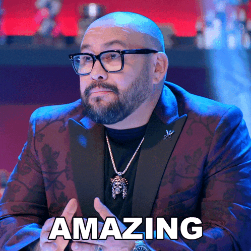 a bald man with glasses and a necklace says " amazing "