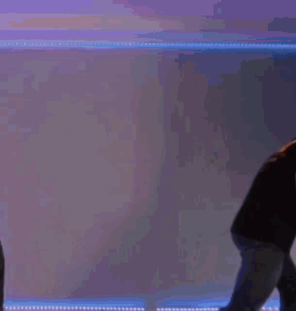 a man in a black shirt is holding a blue light saber