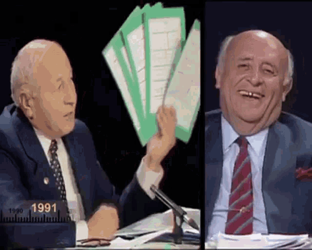 a man in a suit and tie is holding a stack of papers and smiling ..