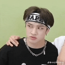 a young man wearing a headband that says bape and a necklace .