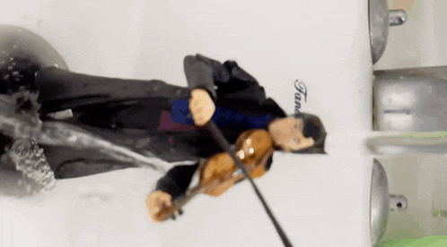 a figurine of a man playing a violin in front of a tank