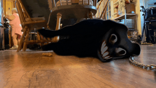 a cartoon character is laying on the floor with a chain around its neck