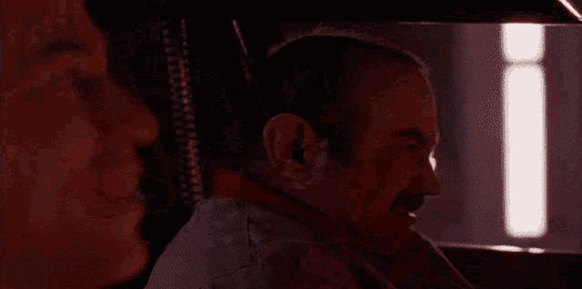 a man with a mustache is talking to another man in a car