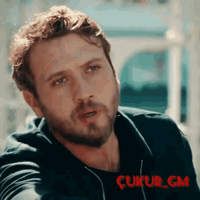 a close up of a man 's face with the words çukur_gm in red