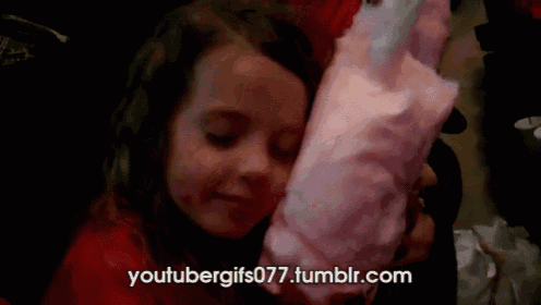 a little girl eating pink cotton candy with the website youtubergifs077.tumblr.com in the background