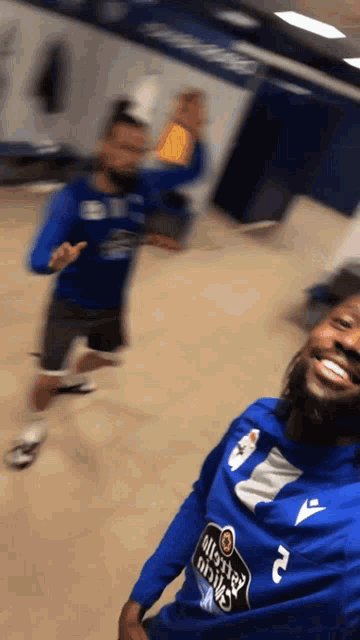 a man wearing a blue shirt that says estrella galicia on it