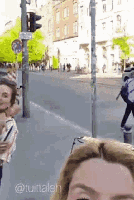 a woman taking a picture of herself on a street with the hashtag @tuittalen on the bottom