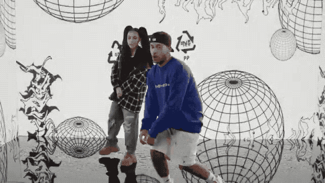 a man and a woman are dancing in front of a wall that has the word pp written on it