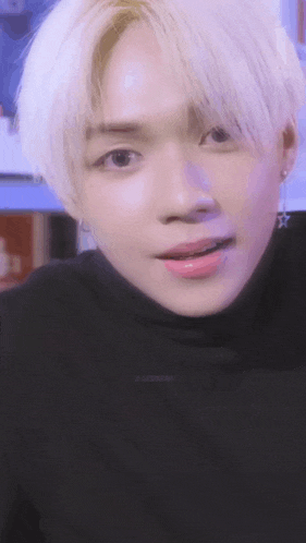 a close up of a person 's face wearing a black turtleneck .