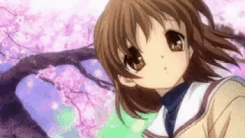 a girl with brown hair is standing in front of a tree with pink flowers .