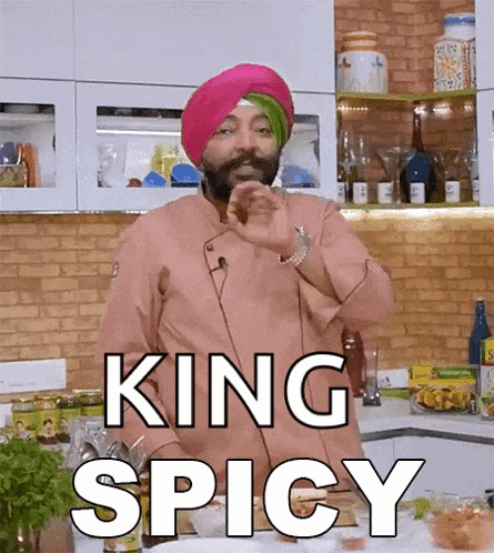 a chef with a turban on says king spicy in a kitchen .