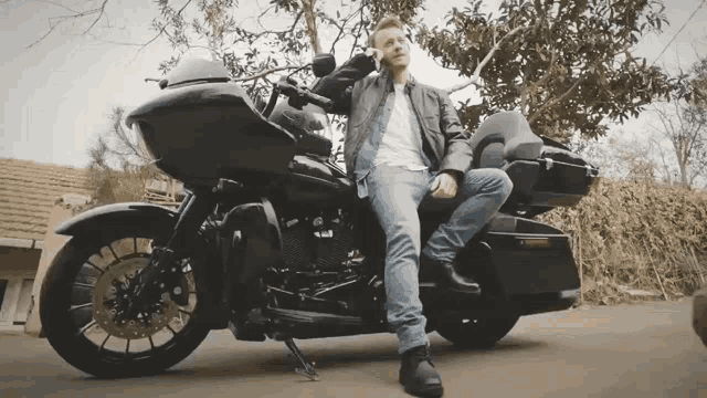 a man is sitting on a black motorcycle
