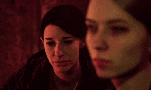 two women are looking at each other in a red light
