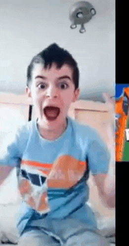 a young boy in a blue shirt is making a funny face .