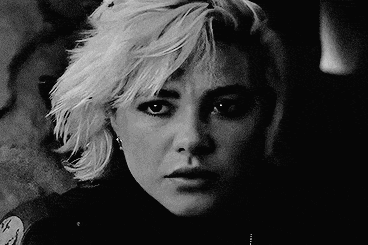 a black and white photo of a woman 's face with blonde hair .