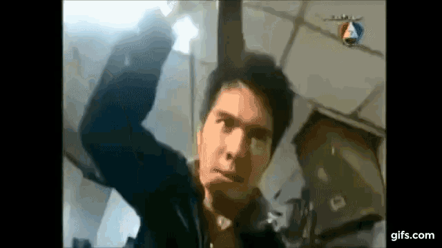 a man in a black jacket is holding a sword in his hand .
