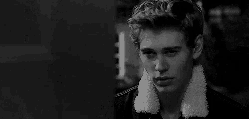 a black and white photo of a young man wearing a denim jacket with a sherpa collar .