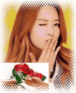 a woman blowing a kiss next to a red rose