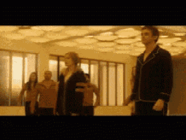 a group of people standing in a room with a ceiling that looks like a honeycomb
