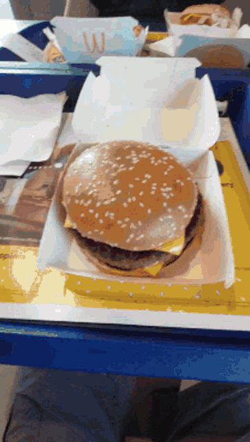 a mcdonald 's hamburger is sitting on a blue tray