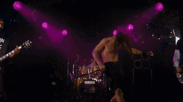 a man in a shirt that says scorpion is playing a guitar on stage