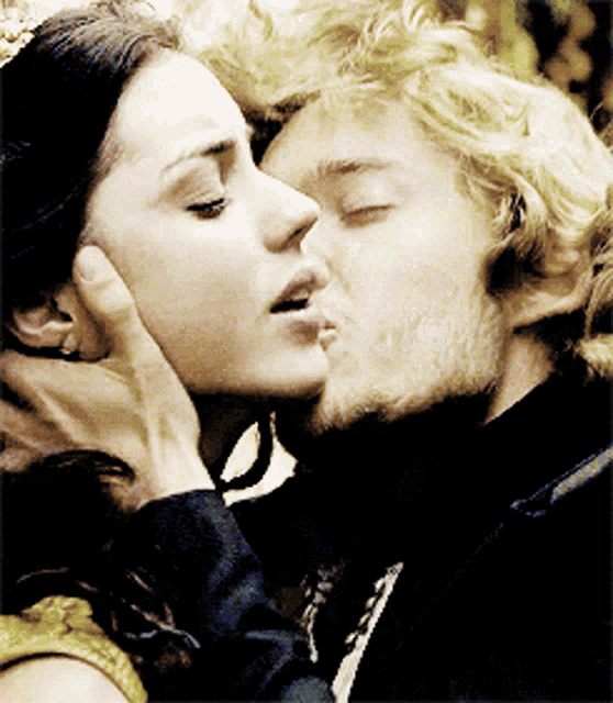 a man is kissing a woman on the forehead