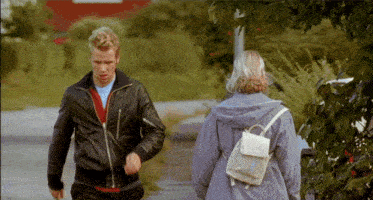 a man and a woman are walking down a path
