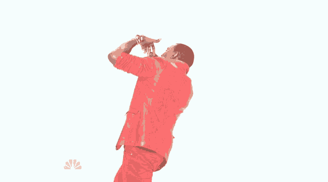 a man in a red suit singing into a microphone with his arms outstretched