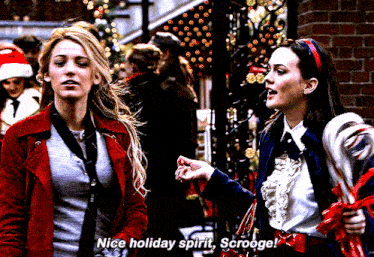 two women are standing next to each other and one of them says nice holiday spirit scroogee