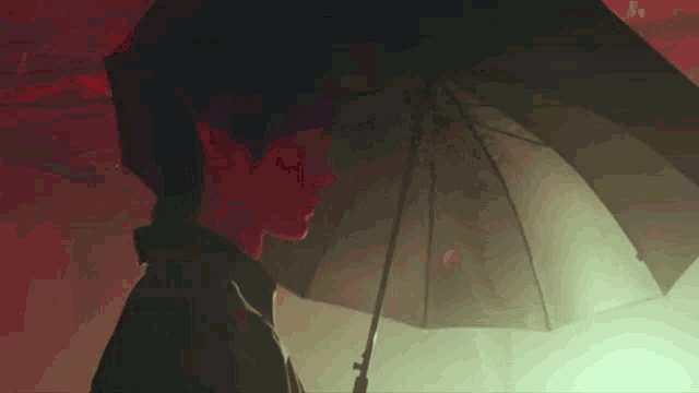 a man is holding a black umbrella in the dark .