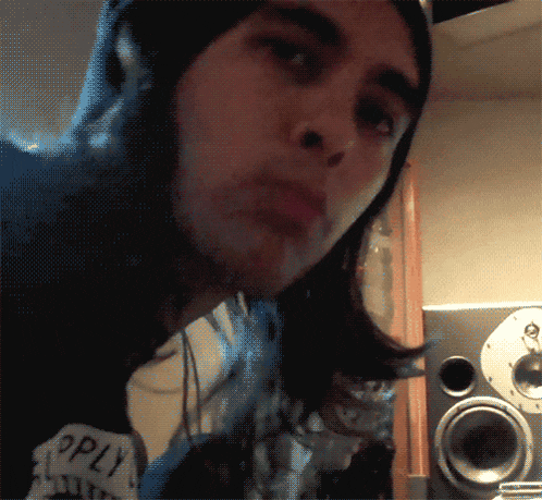 a man with long hair is wearing a black beanie and a shirt that says ' supply ' on it