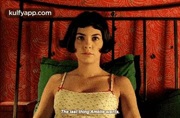 a woman is laying on a bed with a green pillow and says the last thing amélie wants .