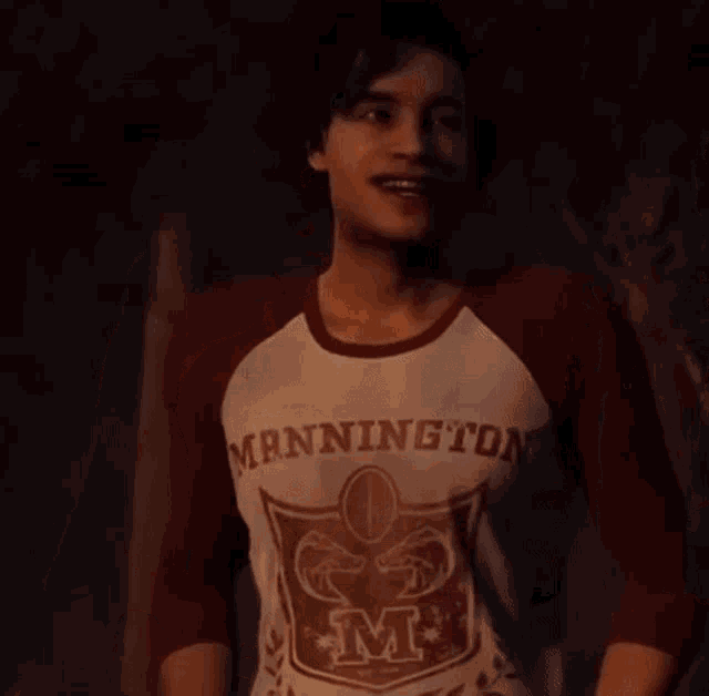 a man wearing a manningto shirt holds a woman 's hand