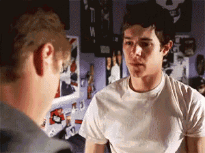 a man in a white shirt is talking to another man in a room