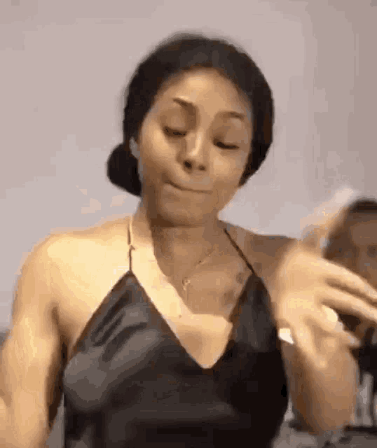 a woman in a black top is making a funny face while dancing .
