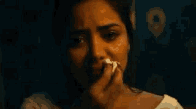 a woman is crying while holding a piece of paper in her hand .