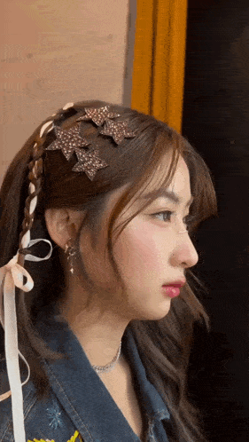 a close up of a woman 's face with a braid and earrings