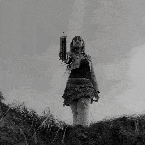 a black and white photo of a woman crawling in a field