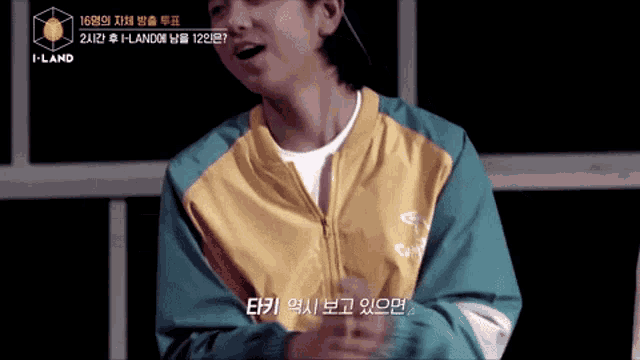 a man wearing a yellow and blue jacket with the words i-land on the bottom