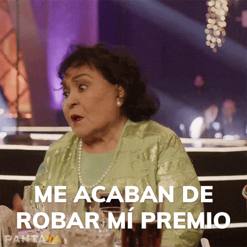 an older woman sitting at a table with the words me acaban de robar mi premio on the bottom