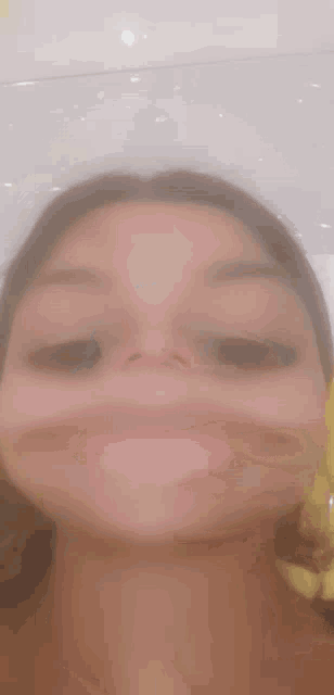 a girl is making a funny face with her mouth open .